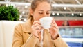 Portrait of beautiful smiling woman enjoying drinking coffee in cafe at shopping mall Royalty Free Stock Photo