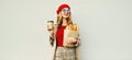 Portrait beautiful smiling woman holding coffee cup, grocery shopping paper bag with long white bread baguette over blank gray Royalty Free Stock Photo