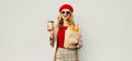 Portrait beautiful smiling woman holding coffee cup, grocery shopping paper bag with long white bread baguette over blank gray Royalty Free Stock Photo