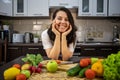 portrait of beautiful smiling woman at the kitchen with fruits and vegetables on the table Royalty Free Stock Photo