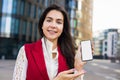 Portrait of a beautiful smiling woman professional business worker looking in camera and holding in hand mobile phone Royalty Free Stock Photo