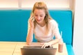 Portrait of beautiful smiling woman sitting on a comfortable chair in a cafe with black laptop. Pretty student doing work with lap Royalty Free Stock Photo