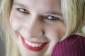 Portrait of a beautiful smiling young blonde woman with red lipstick and intense gaze Royalty Free Stock Photo