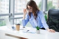 Portrait of beautiful smiling young brunette business woman sitting at bright modern office Royalty Free Stock Photo