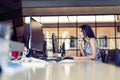 Portrait of beautiful smiling young brunette businesswoman sitting at bright modern work station and typing on computer Royalty Free Stock Photo