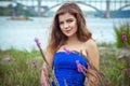 Portrait of beautiful young smiling brunette woman on the meadow near river Royalty Free Stock Photo