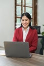 Portrait of beautiful smiling young businesswoman sitting at bright in office modern work and typing on laptop Royalty Free Stock Photo