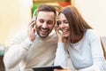 Smiling young couple sitting in cafe using tablet Royalty Free Stock Photo