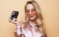 Portrait of a beautiful smiling young girl in pink shirt holding photo camera. Royalty Free Stock Photo