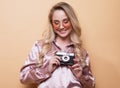 Portrait of a beautiful smiling young girl in pink shirt holding photo camera. Royalty Free Stock Photo