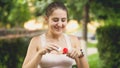 Closeup portrait of beautiful smiling young woman blowing soap bubbles in park at sunset Royalty Free Stock Photo