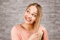 Portrait of a beautiful smiling young woman comb hair, on brick wall background Royalty Free Stock Photo