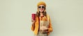 Portrait beautiful smiling young woman holding grocery shopping paper bag with long white bread baguette and cup of coffee on Royalty Free Stock Photo