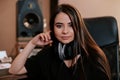 Portrait of a beautiful smiling young woman with a pair of headphones around her neck