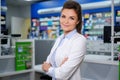 Portrait of beautiful smiling young woman pharmacist standing in pharmacy. Royalty Free Stock Photo