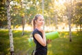 Portrait of a beautiful smiling young woman in a sports uniform with a jump rope and a yoga mat in her hands, posing Royalty Free Stock Photo