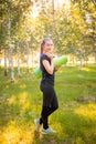 Portrait of a beautiful smiling young woman in a sports uniform with a jump rope and a yoga mat in her hands, posing Royalty Free Stock Photo