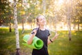 Portrait of a beautiful smiling young woman in a sports uniform with a jump rope and a yoga mat in her hands, posing Royalty Free Stock Photo