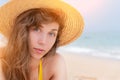 Portrait of a beautiful smiling young woman in a straw hat on the beach against the background of the ocean. The girl Royalty Free Stock Photo