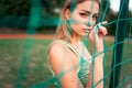 Portrait of a beautiful sports girl with beautiful eyes who stands behind the net of the goal. Royalty Free Stock Photo