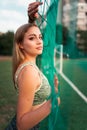 Portrait of a beautiful sports girl with beautiful eyes who stands behind the net of the goal. Royalty Free Stock Photo