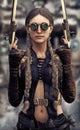 Portrait of a beautiful steampunk woman gunslinger holding two pistols .