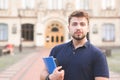 Portrait of a beautiful student man standing with books and notebooks in his hands and looking into the camera Royalty Free Stock Photo