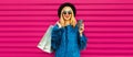 Portrait of beautiful stylish smiling woman with shopping bags wearing blue fur coat, black round hat and sunglasses posing on Royalty Free Stock Photo