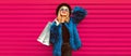 Portrait of beautiful stylish smiling woman with shopping bags wearing blue fur coat, black round hat and sunglasses posing on Royalty Free Stock Photo