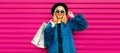 Portrait of beautiful stylish smiling woman with shopping bags wearing blue fur coat, black round hat and sunglasses posing on Royalty Free Stock Photo