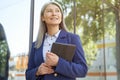 Portrait of a beautiful and succesful mature business woman wearing classic holding digital tablet, looking aside and Royalty Free Stock Photo