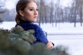 Portrait of a beautiful sweet girl with a beautiful make-up near the Christmas tree in winter bright day Royalty Free Stock Photo