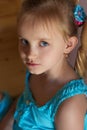 Portrait of a beautiful sweet little girl in a blue dress with blue eyes