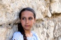 Portrait beautiful tanned caucasian girl against ancient stone wall. Attractive young tourist woman visiting city street Royalty Free Stock Photo