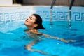 Beautiful tanned woman in bikini relaxing in swimming pool Royalty Free Stock Photo