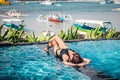 Portrait of beautiful tanned woman in black swimwear relaxing in swimming pool spa. Hot summer day and bright sunny Royalty Free Stock Photo