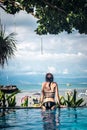 Portrait of beautiful tanned woman in black swimwear relaxing in swimming pool spa. Hot summer day and bright sunny Royalty Free Stock Photo