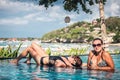 Portrait of beautiful tanned woman in black swimwear relaxing in swimming pool spa. Hot summer day and bright sunny Royalty Free Stock Photo