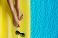 Portrait of beautiful tanned woman relaxing in swimming pool. Legs and hands close up. Sunglasses. Creative gel polish red Royalty Free Stock Photo