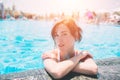 Portrait of beautiful tanned woman in white swimwear relaxing in swimming pool spa. Hot summer day and bright sunny Royalty Free Stock Photo