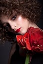 Portrait of a beautiful teen girl with bright makeup. With afro curls and red lipstick and a red flower on the face Royalty Free Stock Photo