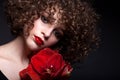 Portrait of a beautiful teen girl with bright makeup. With afro curls and red lipstick and a red flower on the face Royalty Free Stock Photo