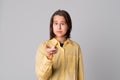 Portrait of beautiful teen girl is pointing finger at camera, looking at camera, wearing casual yellow shirt Royalty Free Stock Photo