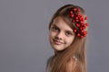 Portrait of a beautiful teenage girl with a bunch of berries in her hand and in her hair