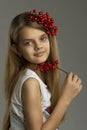 Portrait of a beautiful teenage girl with a bunch of berries in her hand and in her hair