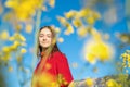 Portrait of beautiful teenager girl in yellow flowers at blue sky background Royalty Free Stock Photo