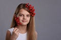 Portrait of a beautiful ten year old girl with a bunch of berries in her hand and hair