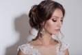 Portrait of a beautiful tender young bride with evening festive hair and gentle make-up in a snow-white dress with a train Royalty Free Stock Photo