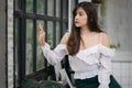 Portrait of Beautiful Thai office woman sitting and looking outside window alone at home Royalty Free Stock Photo