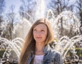 Portrait of a beautiful thoughtful blond woman on a background of a fountain